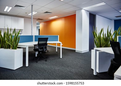 Sydney, NSW/Australia-July 14 2017: Interior Photography Of A Corporate Fit Out Open Plan Office Area With Desks, Filing Cabinets, Chairs, Planter Boxes, Orange Feature Wall And Blue Partioning