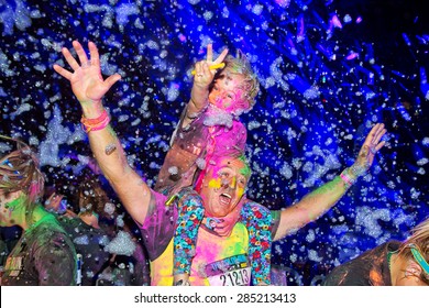 SYDNEY,AUSTRALIA - JUNE 6,2015: Adults And Children In The Color Run Night 5K Fun Run. Runners Encounter Bubble Blowers, Coloured Powder And UV Light, Joining A Dance Party At The Finish.