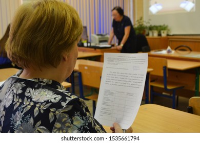 Syktyvkar, Russia - April, 2018. Teacher At University In Front Of A Whiteboard Screen. Another Teacher Sits At Her Desk And Looks At The Handout.