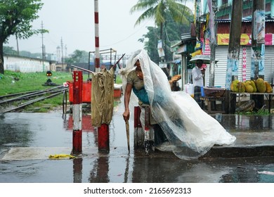 Sylhet 9 Jun 2022: A Mentally Unbalanced Woman Is Sitting In The Rain With Polythene Sheet On Her Head. Sylhet, Bangladesh. 