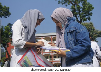 Sylhet, Bangladesh - 14 November 2021: After Giving SSC (secondary School Certificate) Exam, Two Students Are Talking In Front Of The Exam Center With Question Papers In Their Hands.