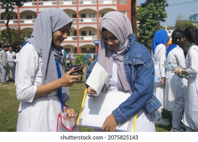 Sylhet, Bangladesh - 14 November 2021: After Giving SSC (secondary School Certificate) Exam, Two Students Are Talking In Front Of The Exam Center With Question Papers In Their Hands.