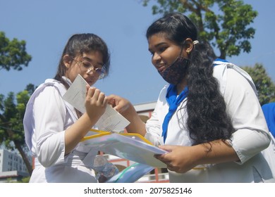 Sylhet, Bangladesh - 14 November 2021: After Giving SSC (secondary School Certificate) Exam, Two Students Are Talking In Front Of The Exam Center With Question Papers In Their Hands.