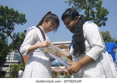 Sylhet, Bangladesh - 14 November 2021: After Giving SSC (secondary School Certificate) Exam, Two Students Are Talking In Front Of The Exam Center With Question Papers In Their Hands.