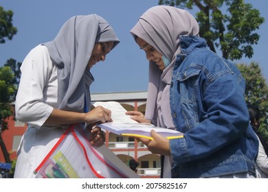 Sylhet, Bangladesh - 14 November 2021: After Giving SSC (secondary School Certificate) Exam, Two Students Are Talking In Front Of The Exam Center With Question Papers In Their Hands.