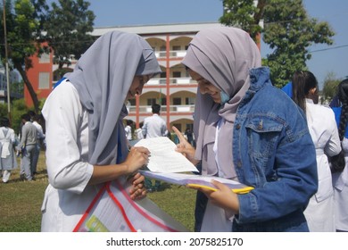 Sylhet, Bangladesh - 14 November 2021: After Giving SSC (secondary School Certificate) Exam, Two Students Are Talking In Front Of The Exam Center With Question Papers In Their Hands.