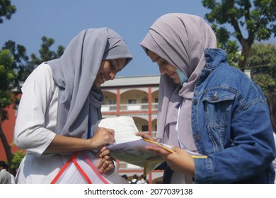 Sylhet, Bangladesh - 14 November 2021: After Giving SSC (secondary School Certificate) Exam, Two Students Are Talking In Front Of The Exam Center With Question Papers In Their Hands.