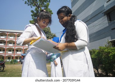 Sylhet, Bangladesh - 14 November 2021: After Giving SSC (secondary School Certificate) Exam, Two Students Are Talking In Front Of The Exam Center With Question Papers In Their Hands.