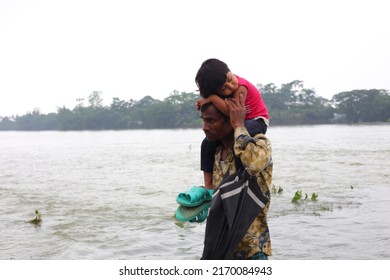 Sylhet, Bangladesh - 20 June 2022: In Flood-hit Sylhet, A Young Man Goes To A Safe Place With His Child In His Arms.