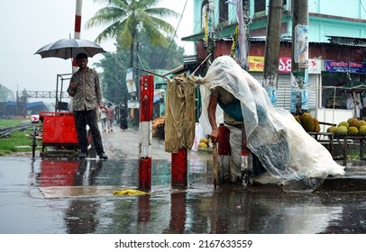 Sylhet, Bangladesh 9 Jun 2022: In The Rain, A Mentally Unbalanced Woman Is Sitting On The Street With Polythene Wrapped Around Her Head.