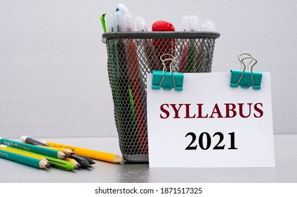 SYLLABUS 2021 - word on a white sheet with clips against the background of cans of pencils. Business and education concept.