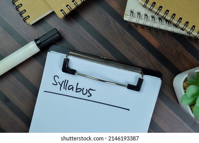 Syllabus write on a paperwork isolated on Wooden Table.