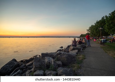 SYLVAN BEACH, NEW YORK - JULY 3, 2019: Sunset at Sylvan Beach of the Oneida lake while people waiting for the Independence Day Fireworks.