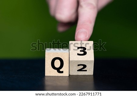 Symbol for the 3rd Quarter of the year. Hand turns dice and changes the expression Q2 to Q3.