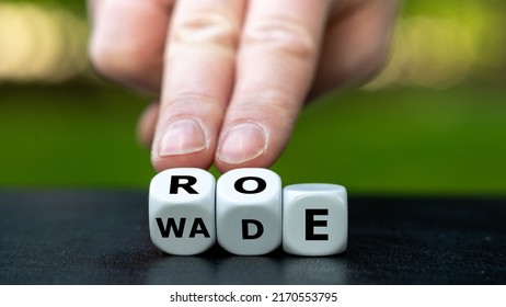 Symbol of the abortion process Roe versus Wade. Hand turns dice and changes the word Wade to Roe.