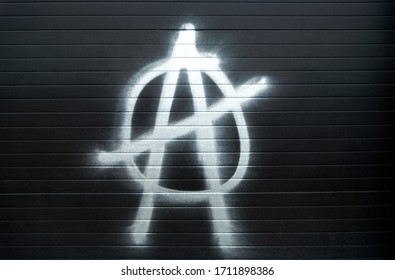 símbolo de anarquía letra a en un círculo pintura con pintura metálica en aerosol sobre una ciega de una tienda