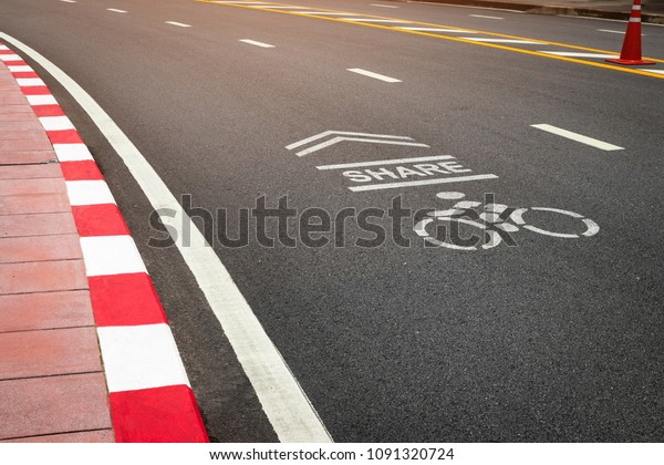 The symbol of the\
bike lane on the street. Sign on the cycling way meaning please\
share lane for bikers.