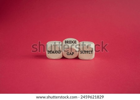 Symbol for closing the gap between a demand and the supply. Turned cube and changes the word gap to bridge between the two words demand and supply. Beautiful red background. Business concept. Copy spa