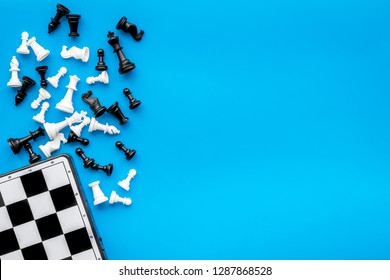 Symbol of competition. Chess board and chess figures on blue background top view copy space