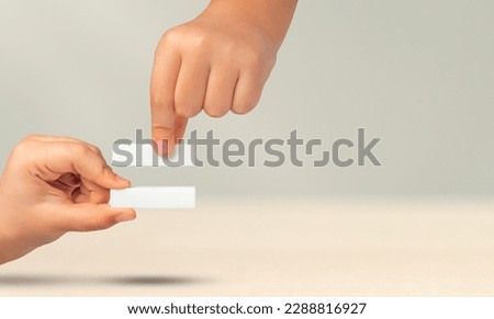 The symbol is equal in the hands of a child on a gray background. Two hands with an equals sign show a sign meaning equality. The concept of equal rights. Stop racism. Equal rights for men and women.