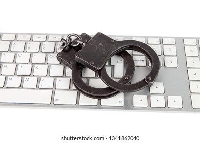 The Symbol Of The Fight Against Cybercrime - Police Handcuffs On A Computer Keyboard. The Background Is White Isolated.