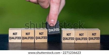 Symbol for finding a qualified candidate. Hand picks wooden cube with the text 'qualified' instead of cubes with the text 'not qualified'.