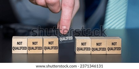 Symbol for finding a qualified candidate. Hand picks wooden cube with the text 'qualified' instead of cubes with the text 'not qualified'.	
