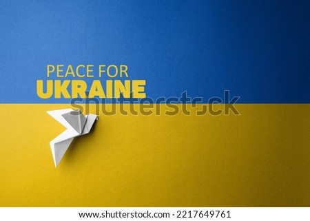symbol of freedom white paper dove on the background of flag of ukraine with blue yellow color with words peace for Ukraine