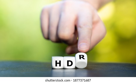 Symbol for a high dynamic range (HDR) television. Hand turns dice and changes the expression "HD" to "HDR".