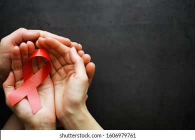 Symbol of human immunodeficiency virus disease. Red ribbon. A helping hand and support. Background.