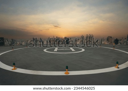 Symbol for landing a helicopter on the rooftop.Heli Copter parking lot on the deck with sunset in the capital of Thailand. Space for helicopter landing on high-rise buildings. 