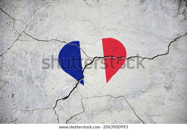 The symbol of the\
national flag of France in the form of a heart on a cracked\
concrete wall. Concept.