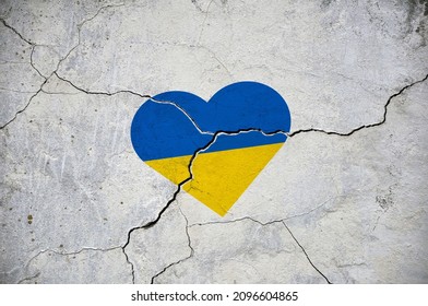 The symbol of the national flag of Ukraine in the form of a heart on a cracked concrete wall. Concept.