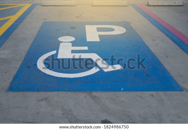 Symbol painted white and blue on parking for\
disabled person.