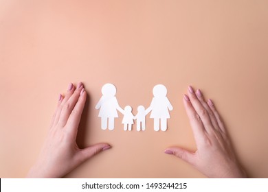 Symbol of same-sex family protection of sexual minorities, a family of white paper. Fashion female hands manicure. View from the top there is a place for inscription. Pink background.