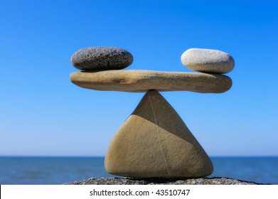 Symbol of scales is made of pebble on the cliff