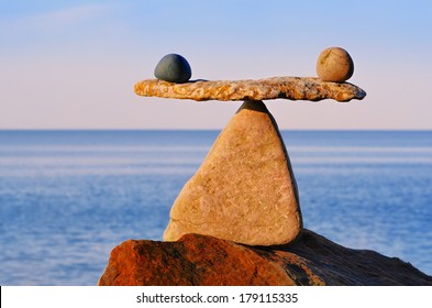 Symbol of scales is made of stones on the boulder  - Shutterstock ID 179115335