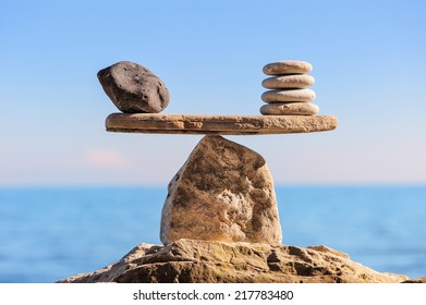 Symbol of scales is made of stones on the boulder  - Shutterstock ID 217783480