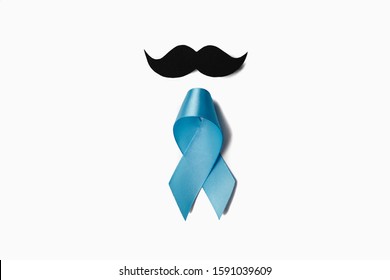 Symbol for support men. Top view on blue Ribbon with mustache for supporting people living and illness. Healthcare, International men, Father and World cancer day concept. Flat lay, copy space