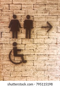 Symbol of toilet for  men , women and disabled people on the brick wall