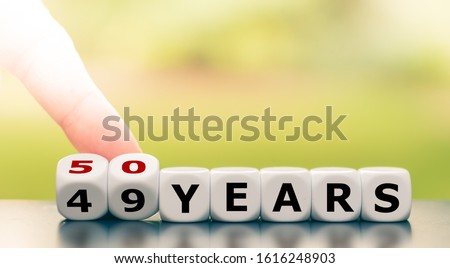 Symbol for turning 50 years old. Hand turns a dice and changes the expression 