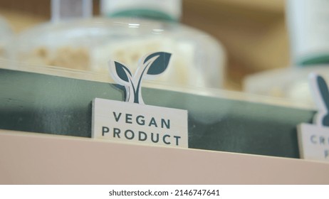 The Symbol Of A Vegan Product With A Picture In The Form Of Green Leaves. Designations Of Vegan Products In The Store. Eco Shop Of Ethical Cosmetics For Conscious People.