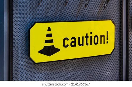 symbol yellow caution sign warning dangerous icon and road cone icon on black barbed wire - Shutterstock ID 2141766367