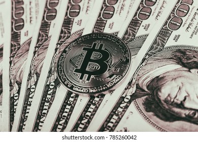 A symbolic coins of bitcoin on banknotes of one hundred dollars. Exchange bitcoin cash for a dollar. - Shutterstock ID 785260042