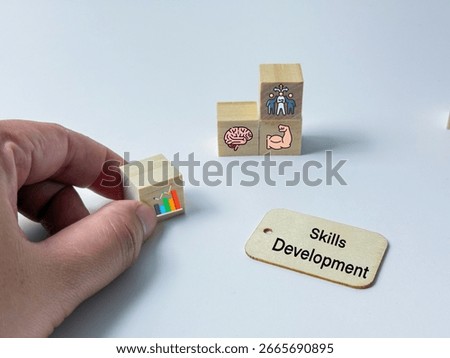 A symbolic image of skills development using wooden blocks with icons representing data, brainpower, strength, and teamwork.