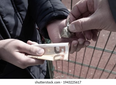 Symbolic Image Of The Social Problem Of School Drug Addiction To Illustrate Crime News Stories. Drug Courier Sells Drugs To A Schoolboy. Close-up, Toned.