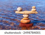 Symbolic scale of the stones on sea background. Concept of harmony and balance. work-life, emotional balance