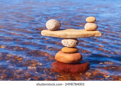 Symbolic scale of the stones on sea background. Concept of harmony and balance. work-life, emotional balance