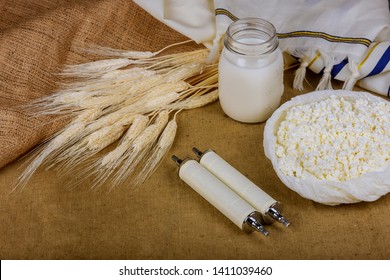 Symbols of jewish holiday torah wheat shavuot kosher food background.