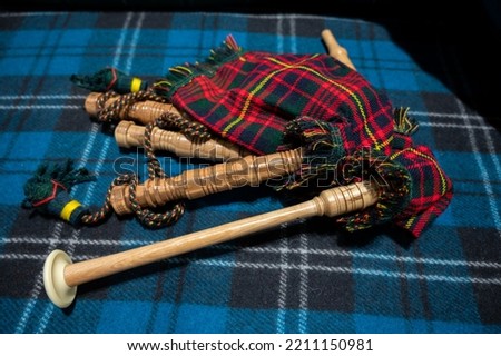 Symbols of Scotland - wollen tartan textile and handmade musical instrument bagpipes, close up